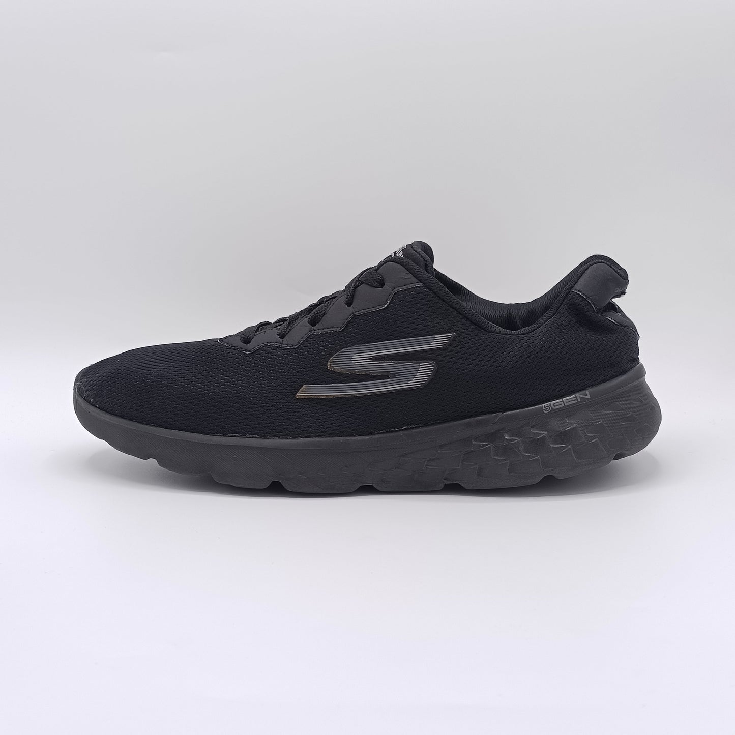 Black running shoe with brand logo on a light gray background